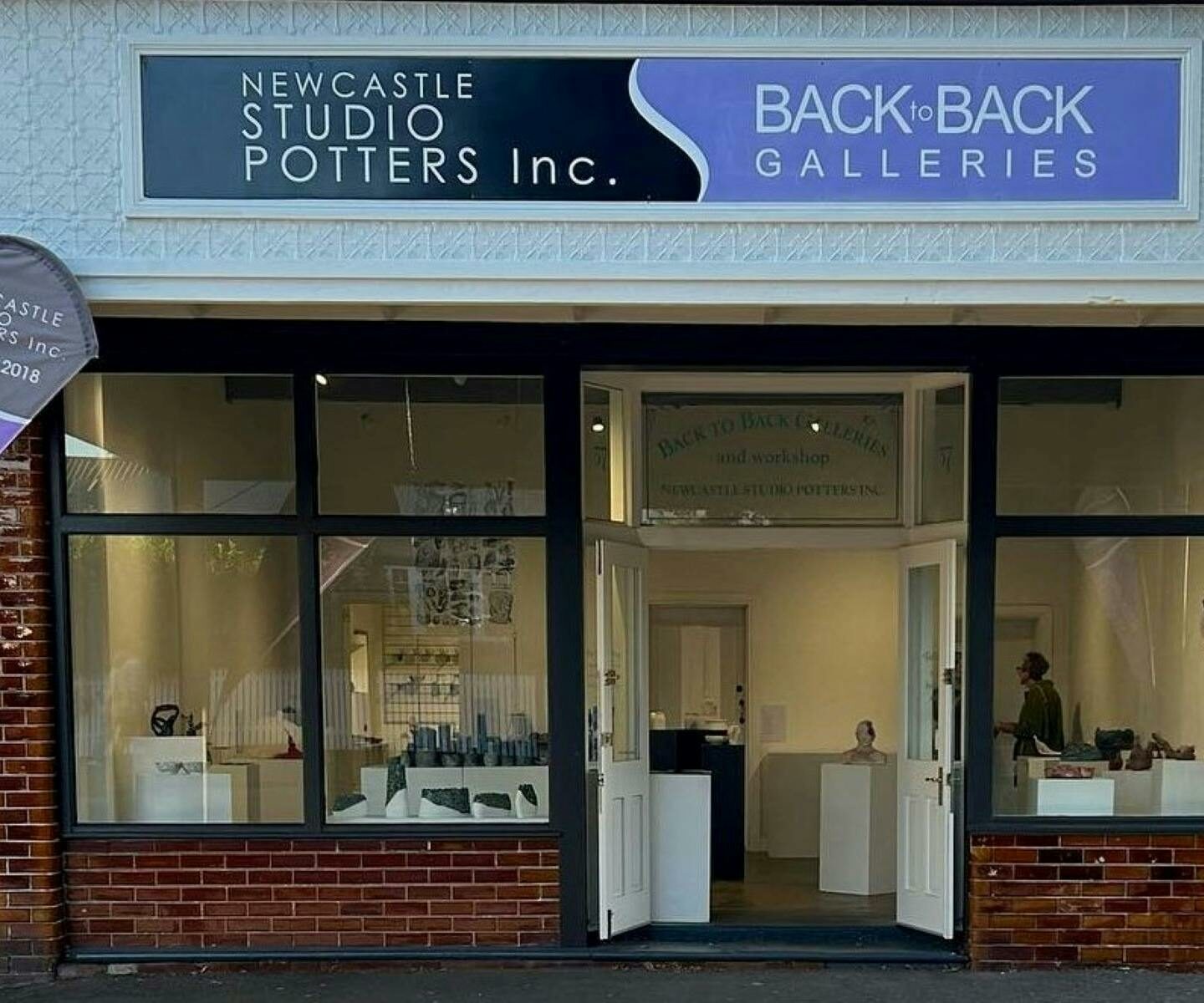 An exterior of a shop window with a sign above that reads Studio Potters Inc and Back to Back Galleries