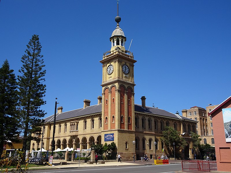 A renaissance-revival style light brown building with a clocktower